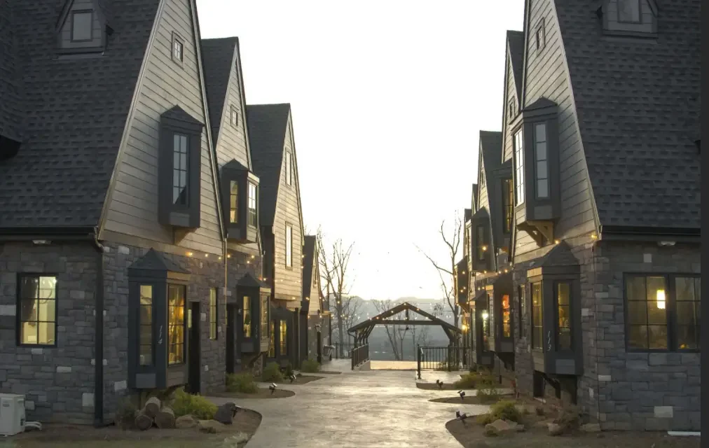 new construction build village castle style with stone exterior gray siding gray roofing